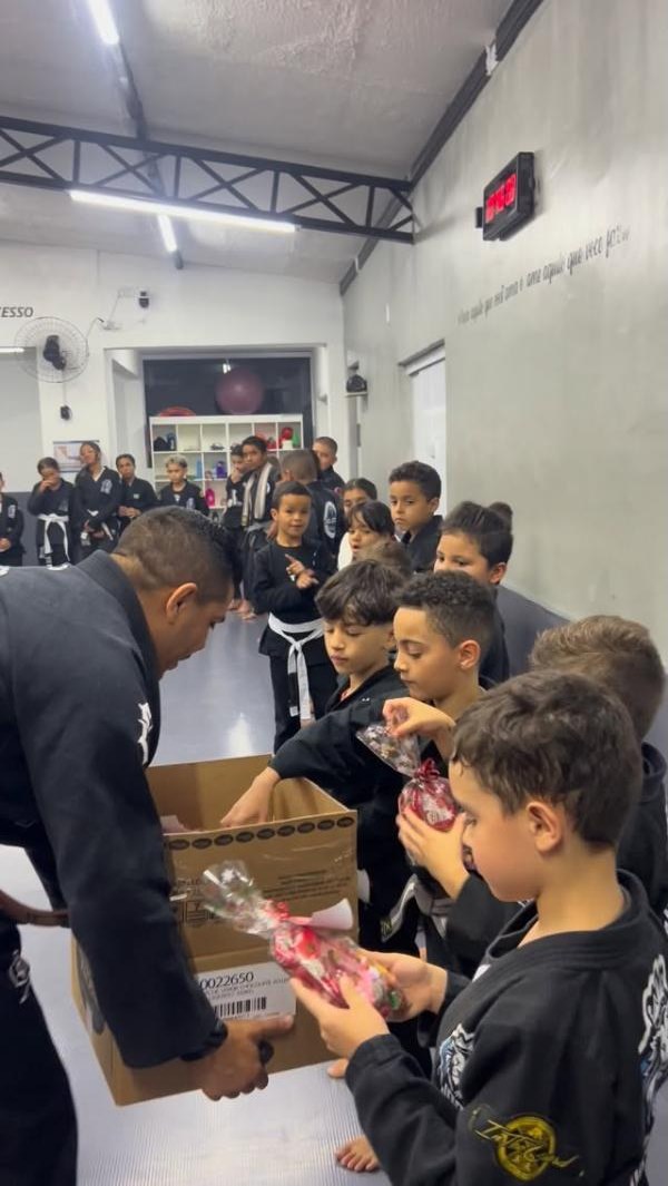 Professor entregando presentes às crianças no encerramento do ano
