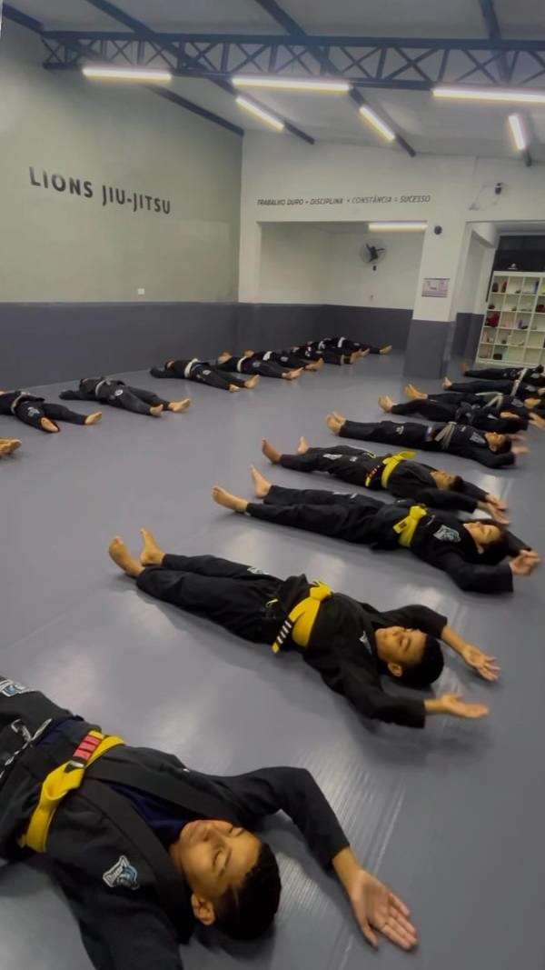 Crianças fazendo aquecimento no tatame