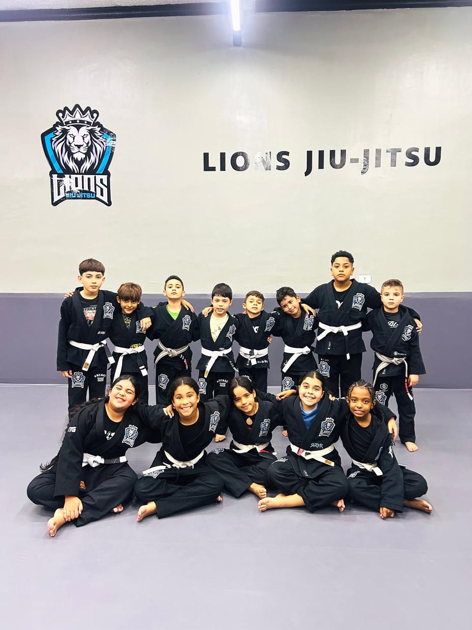 Turma Kids reunida em frente ao logo da Lions